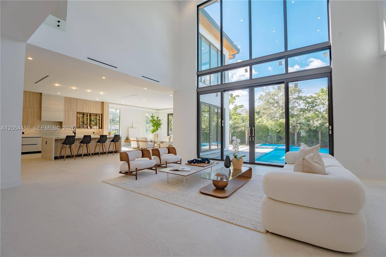 Light filled living area with soaring ceilings and walls of glass to the backyard
