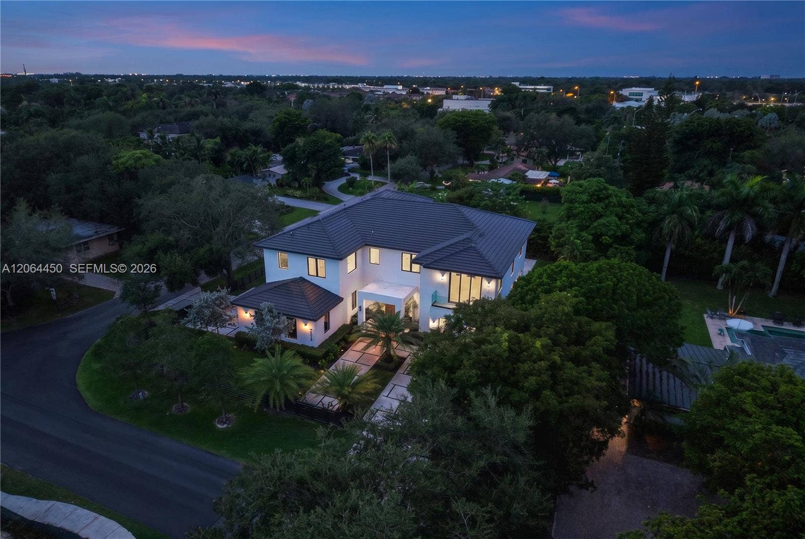 Evening aerial view of the home nestled within a lush, established neighborhood