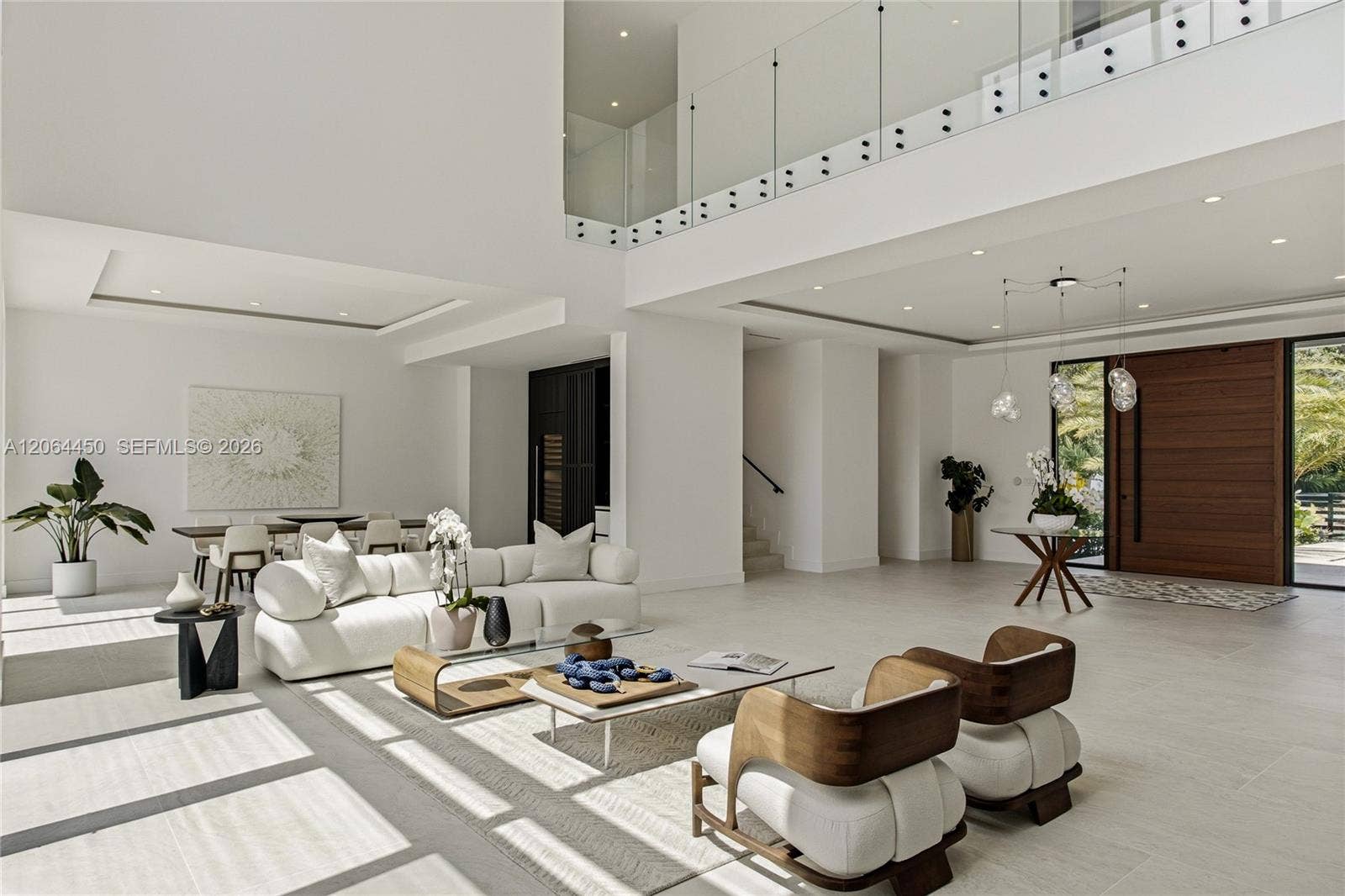 Seamless flow between living, dining, and entry beneath dramatic ceiling heights