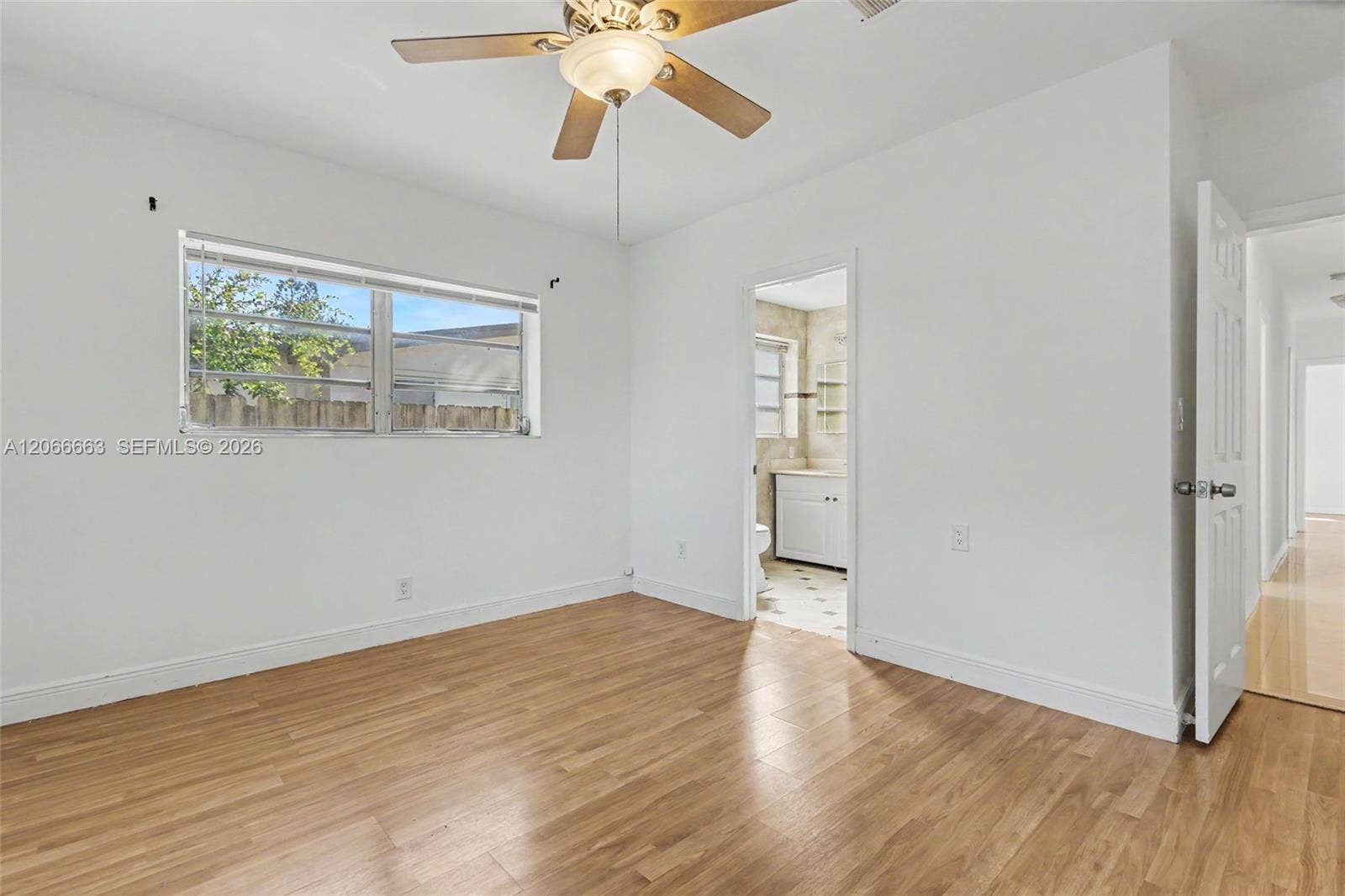 1191 NE 175th Street, North Miami Beach, FL 33162 Neutral-toned room featuring wood-finish flooring, a ceiling fan with integrated light fixture, and horizontal sliding windows