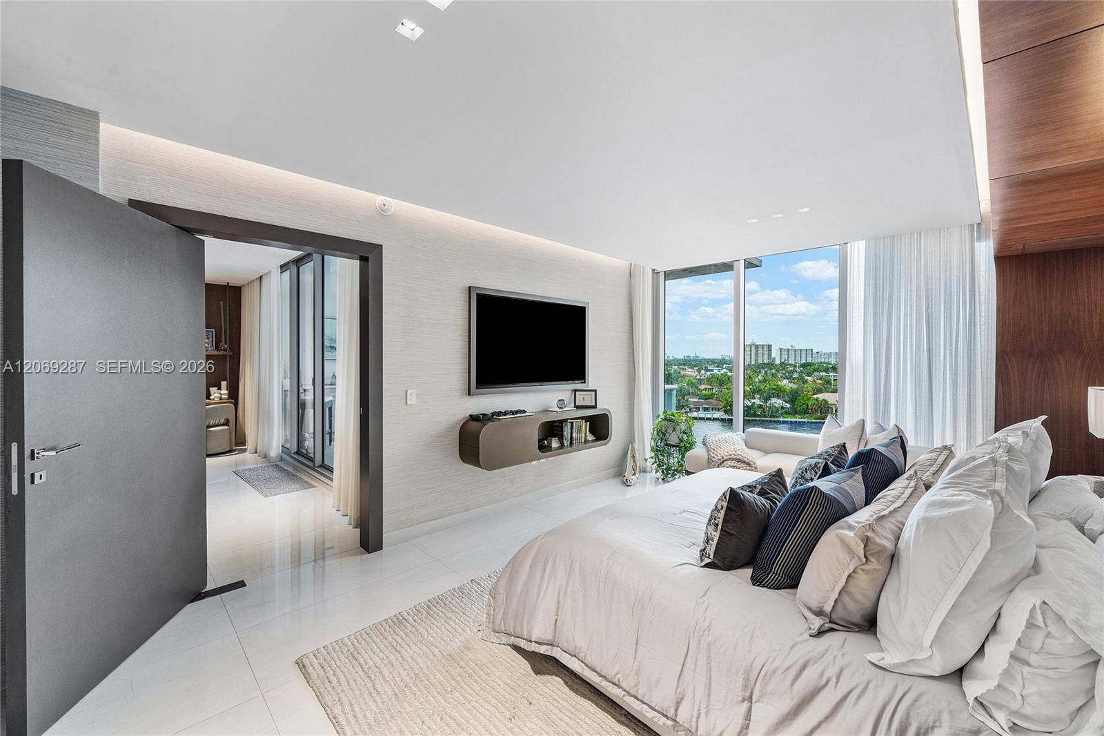 435 Bayshore Drive, #703, Fort Lauderdale, FL 33304 A serene primary suite with floor-to-ceiling glass, private terrace access and captivating waterfront views.