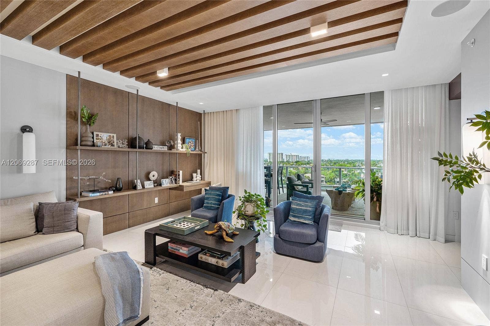435 Bayshore Drive, #703, Fort Lauderdale, FL 33304 An expansive living room offering panoramic waterfront views and seamless access to the terrace.