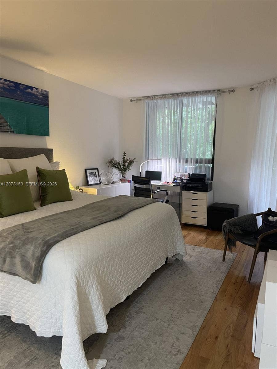 141 Crandon Boulevard, #243, Key Biscayne, Key Biscayne, FL 33149 Bedroom featuring wood-finish flooring and multiple windows with curtain hardware