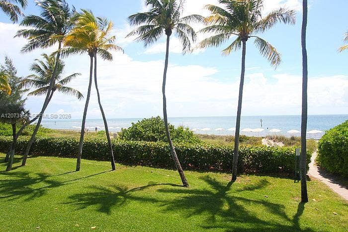 141 Crandon Boulevard, #243, Key Biscayne, Key Biscayne, FL 33149 Manicured lawn featuring mature palm trees, dense landscaping, and a path leading to the water