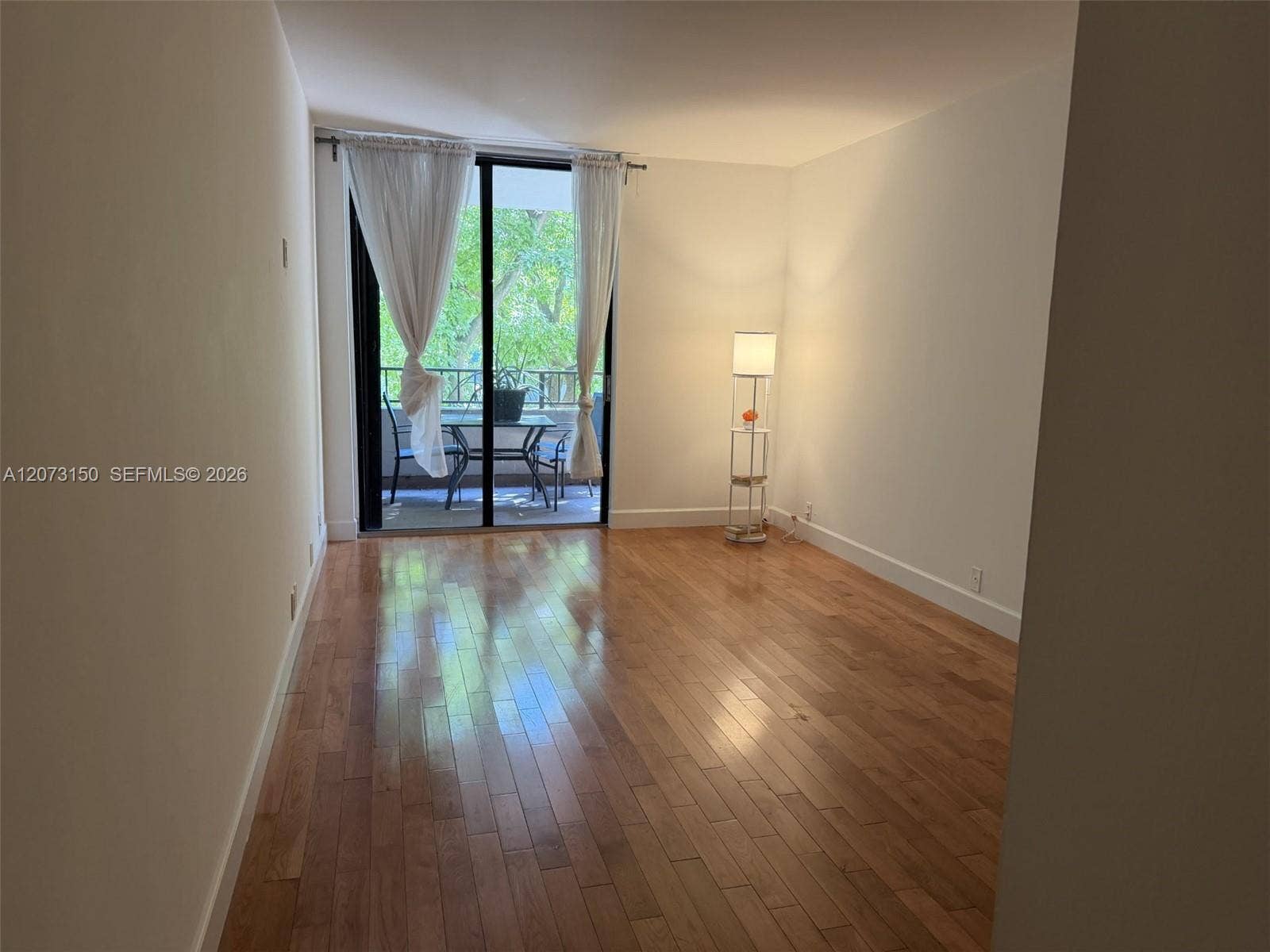 141 Crandon Boulevard, #243, Key Biscayne, Key Biscayne, FL 33149 Living area featuring wood-finish flooring and floor-to-ceiling glass sliding doors opening to a balcony