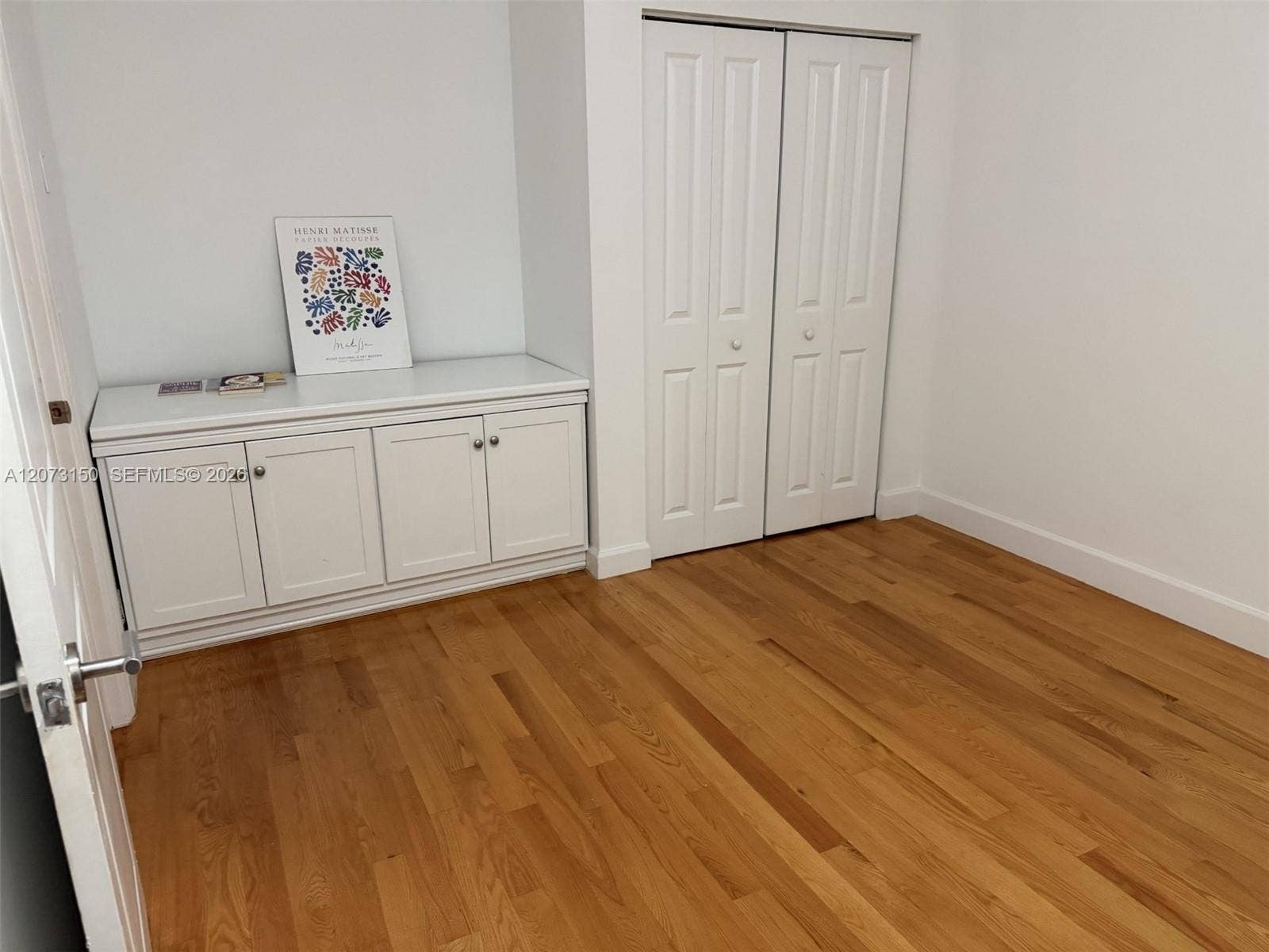 141 Crandon Boulevard, #243, Key Biscayne, Key Biscayne, FL 33149 Wood-finish flooring, built-in white cabinetry with countertop, and bi-fold closet doors