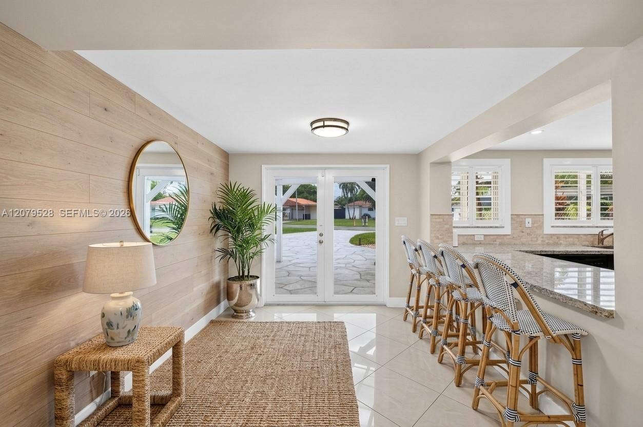 2518 Tortugas Lane, Fort Lauderdale, FL 33312 Great room or Dining Room downstairs, off kitchen, beyond this space are doors to front of house. Come right in here w/ your groceries. Beachy paneled walls. Virtually Staged.