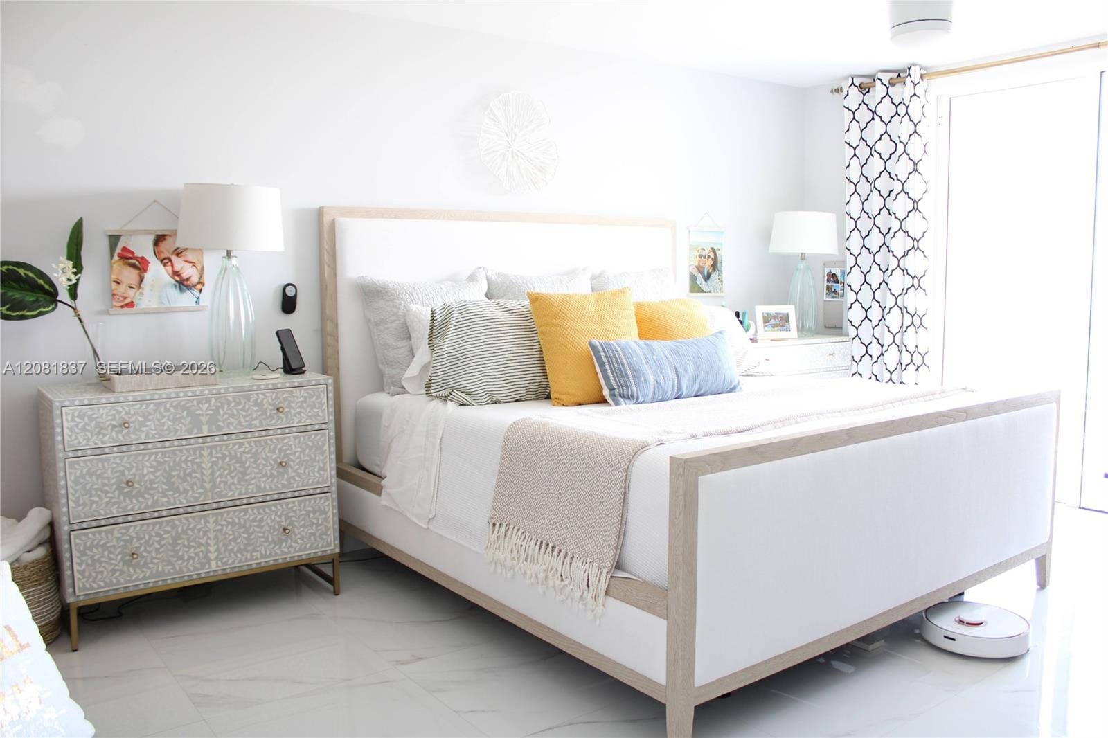 8233 Harding Avenue, #707, Miami Beach, Miami Beach, FL 33141 Light-filled bedroom featuring large-format polished tile flooring and a sliding glass door with patterned drapery