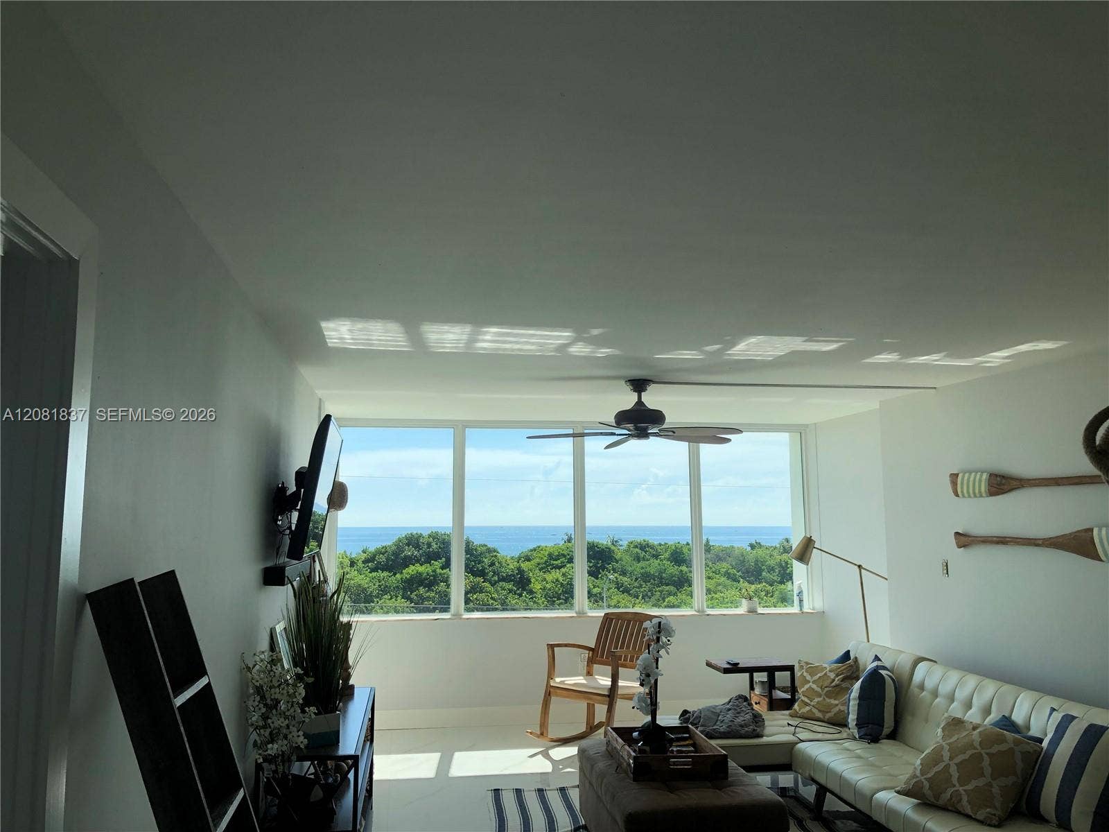 8233 Harding Avenue, #707, Miami Beach, Miami Beach, FL 33141 Floor-to-ceiling windows featuring ocean and treeline scenery, accompanied by an attached ceiling fan