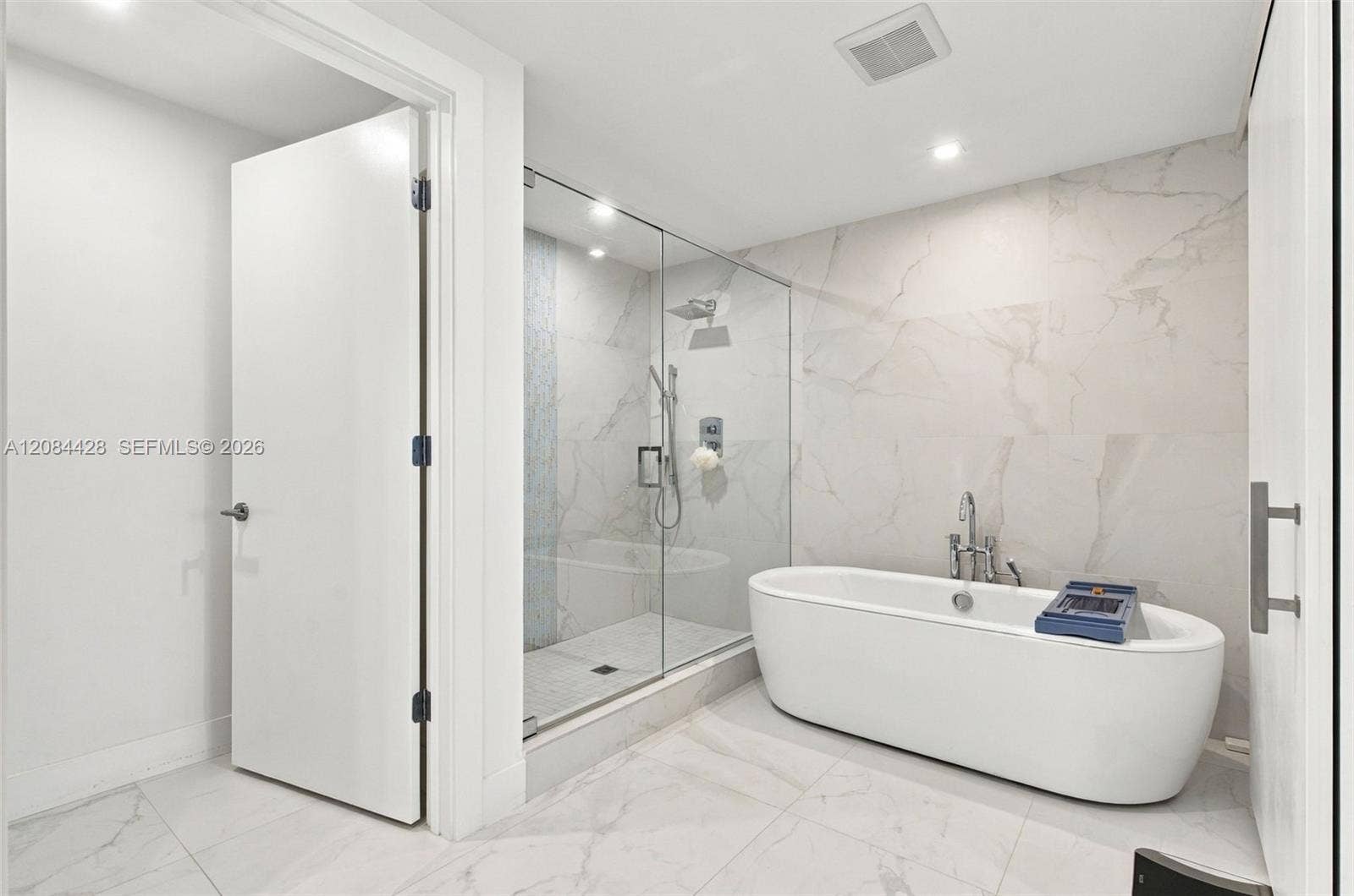 730 N Ocean Boulevard, #601, Pompano Beach, Pompano Beach, FL 33062 Spa-like primary bathroom with a freestanding soaking tub and glass-enclosed shower.