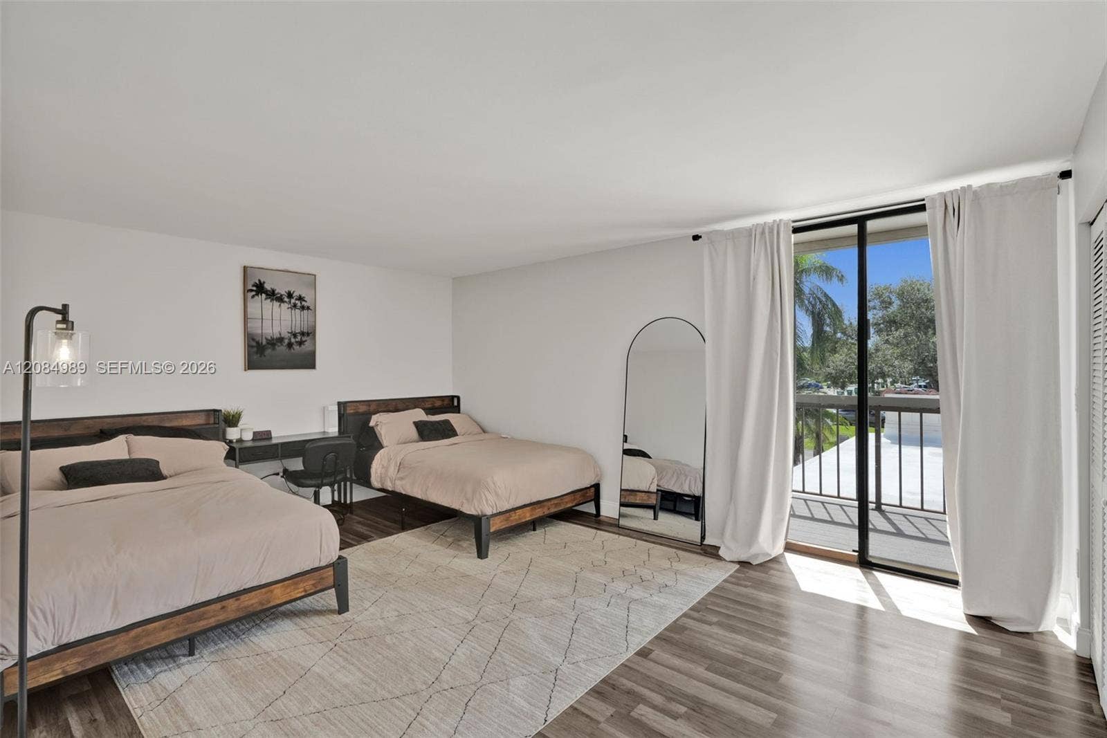 Interior space featuring wood-finish flooring, sliding glass door, and exterior balcony with metal railing