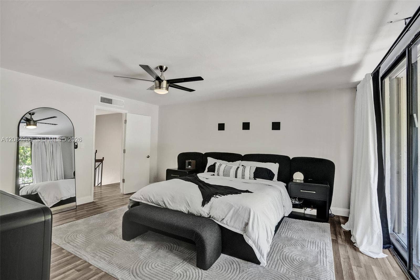 Interior space featuring wood-finish flooring, a contemporary ceiling fan, and sliding glass doors