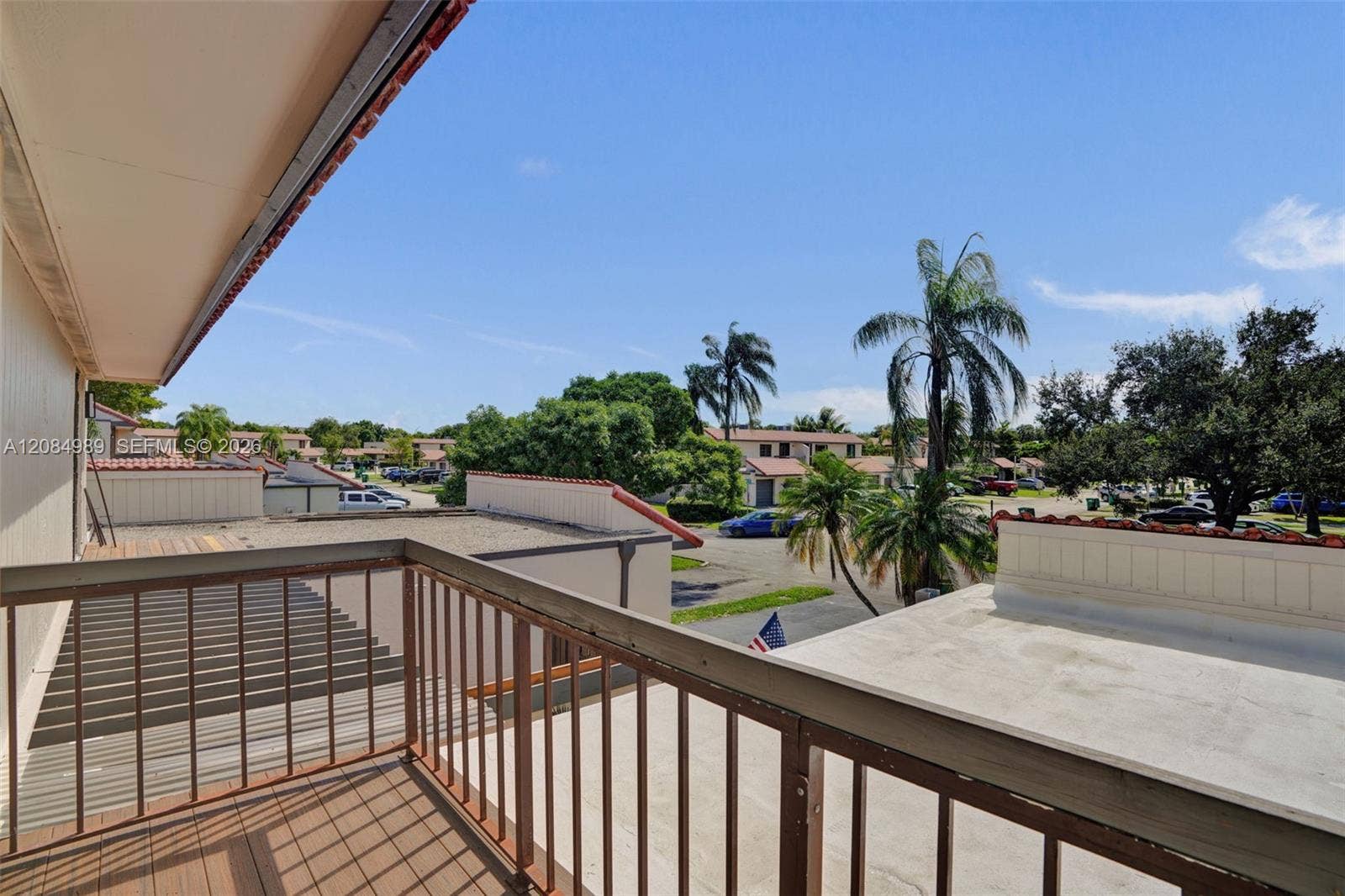 Elevated balcony featuring wood-finish decking and metal railing