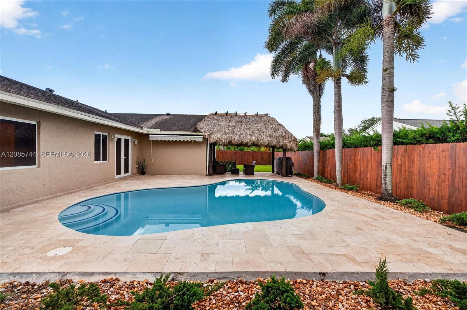 Gorgeous recently resurfaced pool w/ travertine decking, fully fenced, w/ amazing tiki hut, recently rethatched and new sprinkler pump