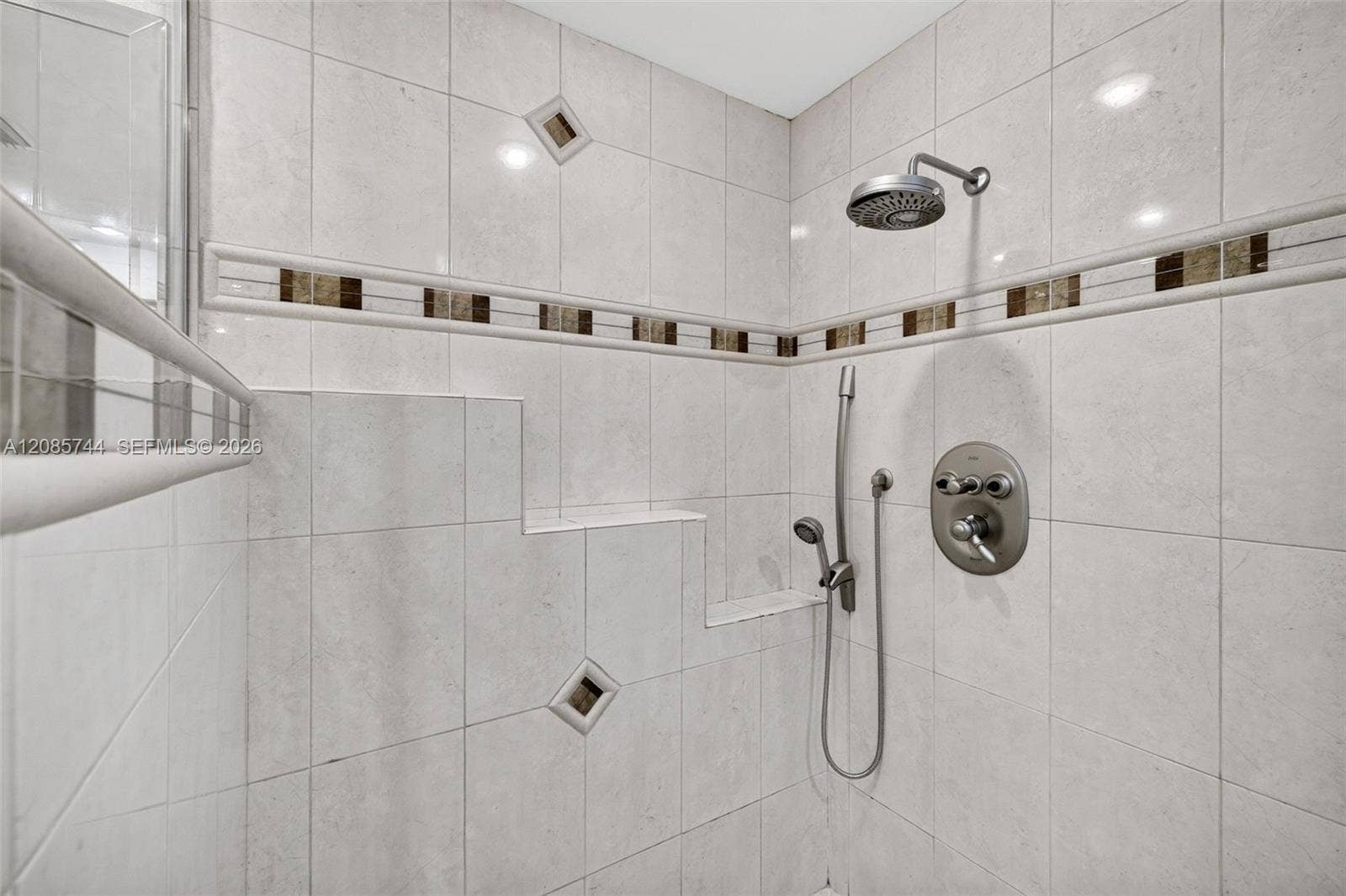 Primary Bath shower w/ frameless shower enclosure and tile to the ceiling.