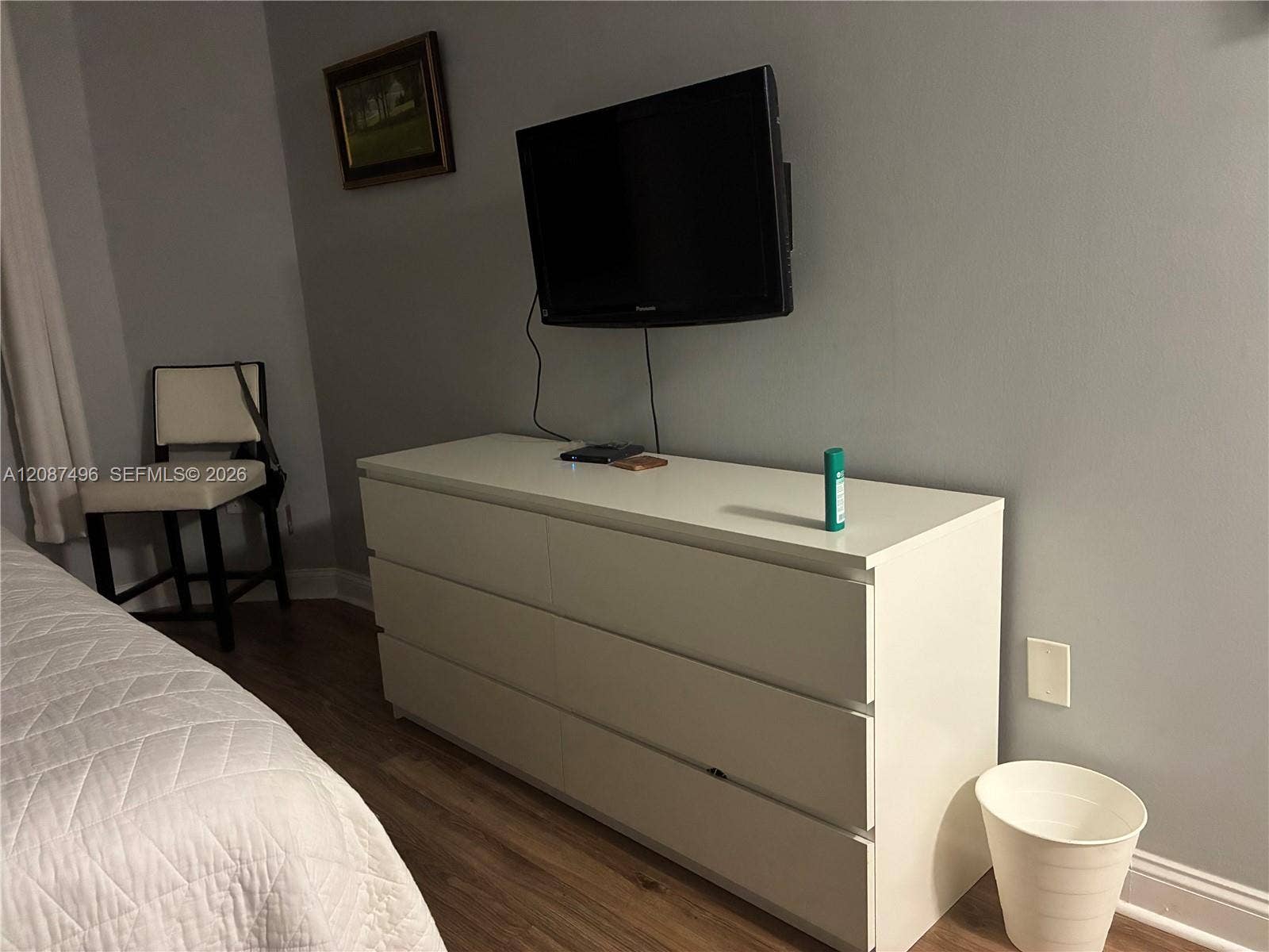 a TV on the wall with a sitting area nearby ..plenty of room to do this or that