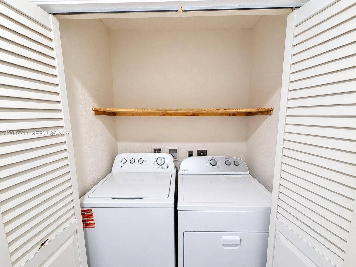 80 NE 162nd Street, Miami, Miami, FL 33162 Laundry closet featuring white louvered doors and an installed wooden shelf