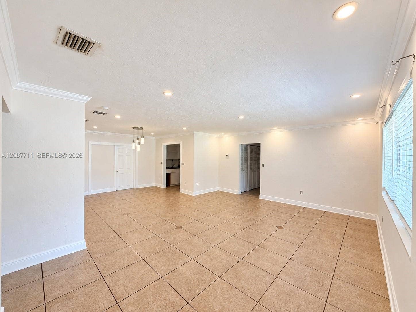 80 NE 162nd Street, Miami, Miami, FL 33162 Open-concept interior featuring large-format ceramic tile flooring, neutral wall tones, recessed lighting, and multi-light pendant fixture