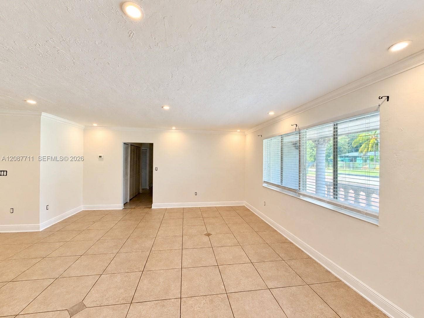 80 NE 162nd Street, Miami, Miami, FL 33162 Neutral-toned tile flooring, recessed lighting, expansive multi-pane window with horizontal blinds, and crown molding
