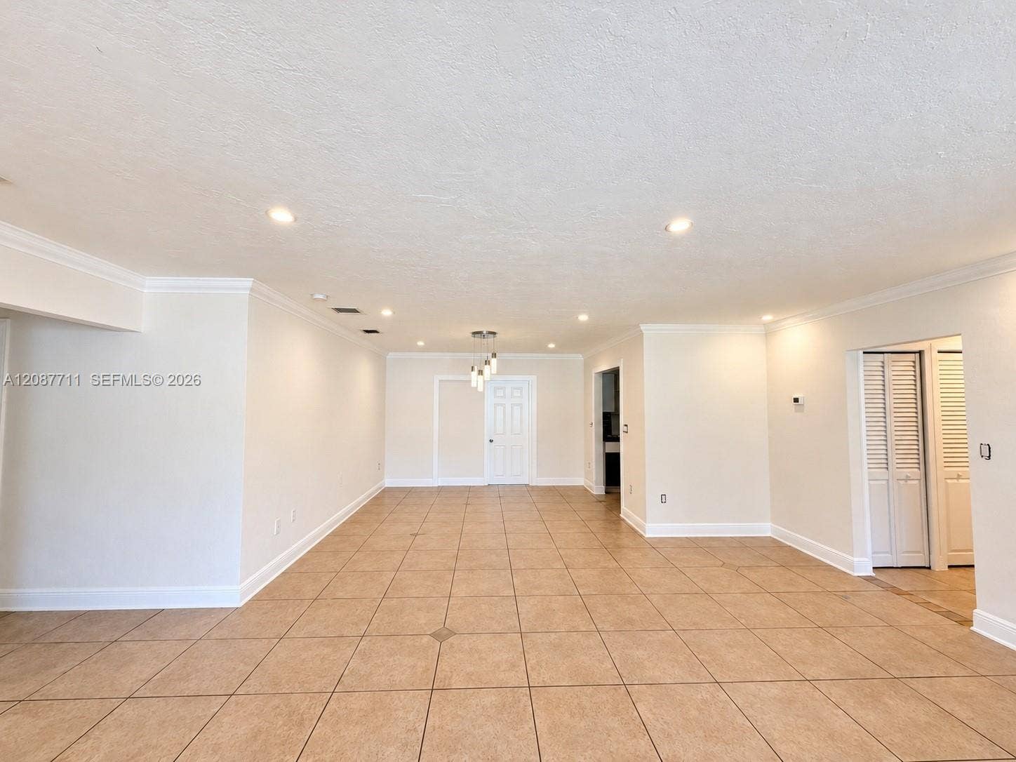 80 NE 162nd Street, Miami, Miami, FL 33162 Open-concept interior featuring oversized tile flooring, recessed lighting, crown molding, and louvered closet doors