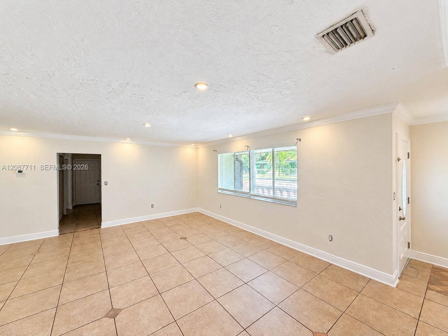 80 NE 162nd Street, Miami, Miami, FL 33162 Neutral-toned tile flooring with decorative inserts, recessed lighting, crown molding, and large windows