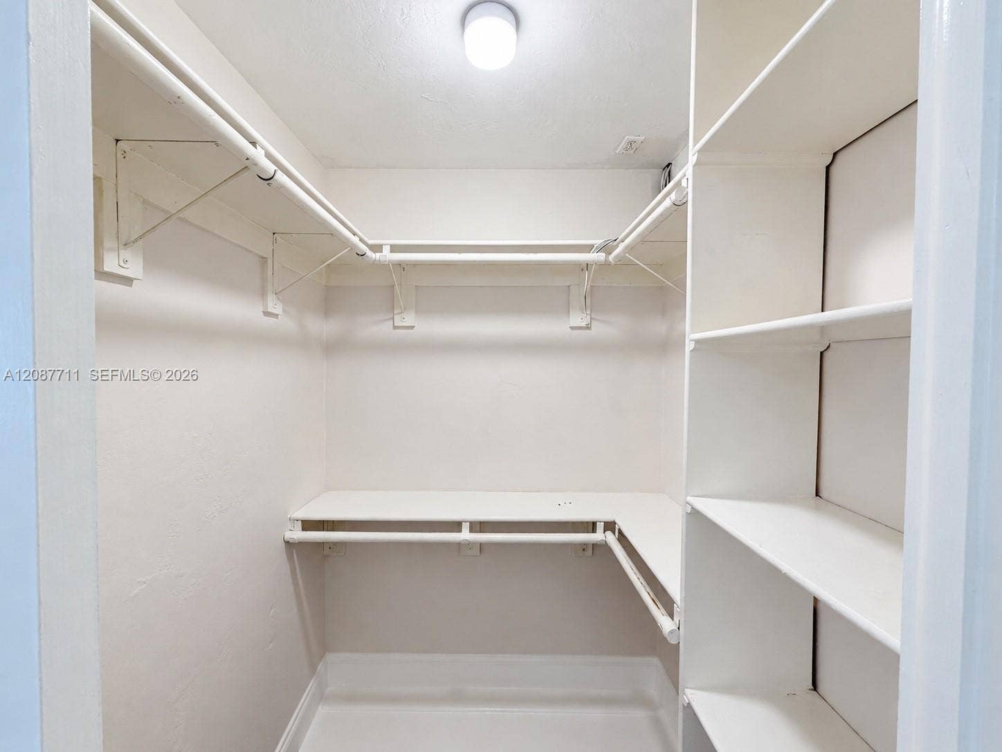80 NE 162nd Street, Miami, Miami, FL 33162 Walk-in closet featuring tiered wrap-around metal garment rods and custom built-in white shelving