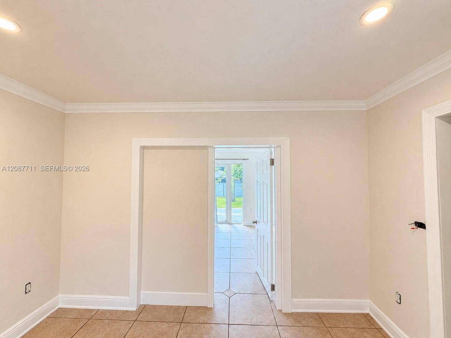 80 NE 162nd Street, Miami, Miami, FL 33162 Neutral-toned interior space featuring crown molding, recessed lighting, and tile flooring with decorative inlay accents