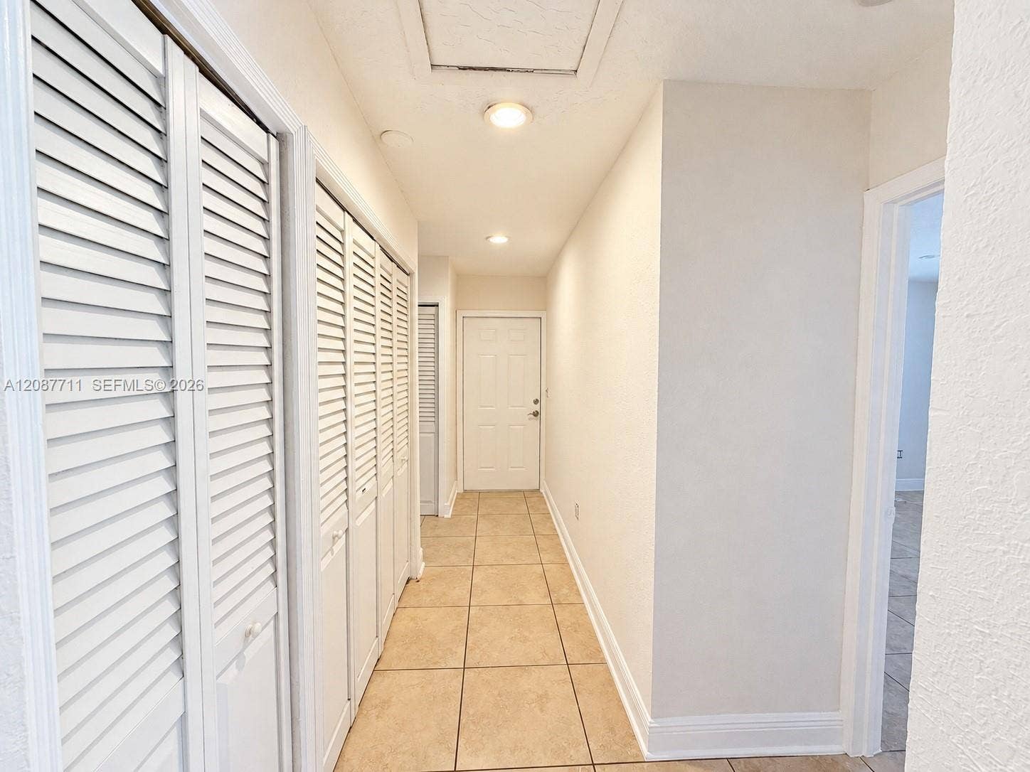 80 NE 162nd Street, Miami, Miami, FL 33162 Hallway featuring ceramic tile flooring, multiple white louvered closet doors, and recessed lighting