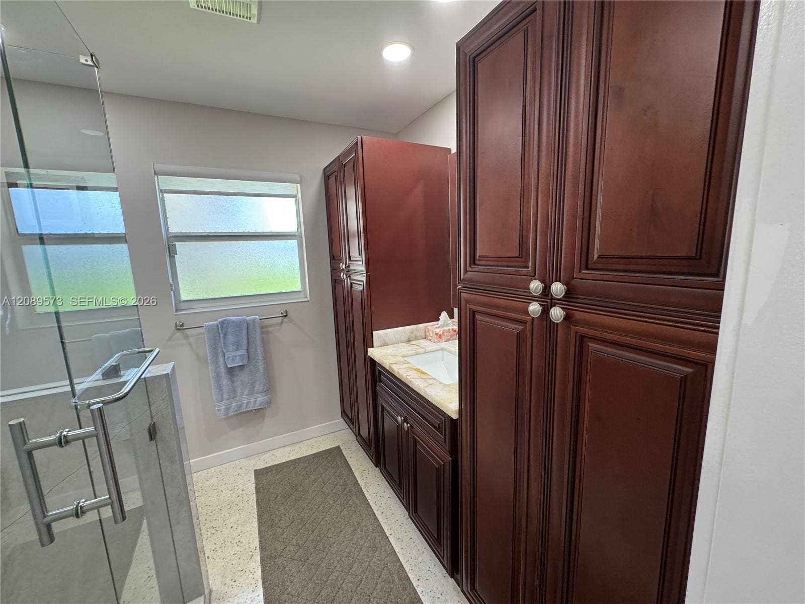 Beautiful custom cabinets in primary bathroom with decorator vanity sink in middle.