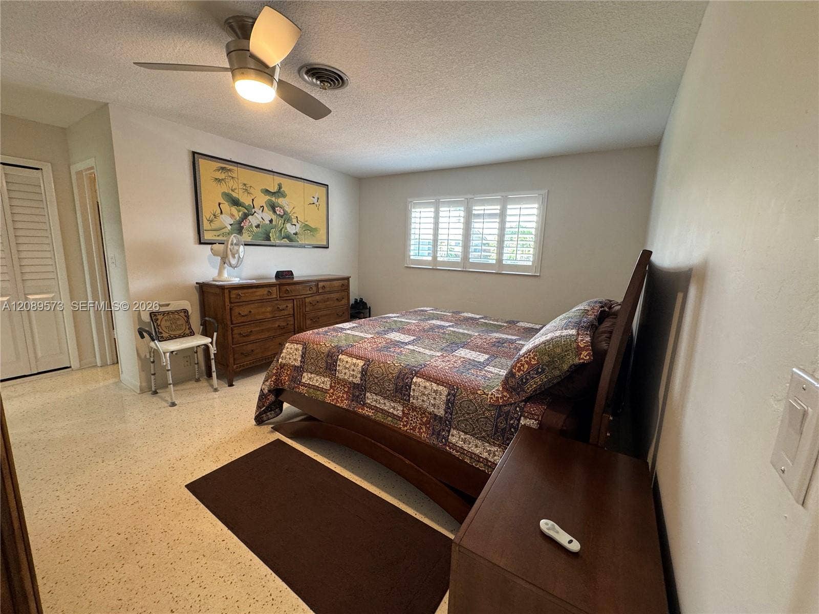 Large primary bedroom with custom Plantation shutters, beautifully restored terrazzo floors. No carpet at all in home.