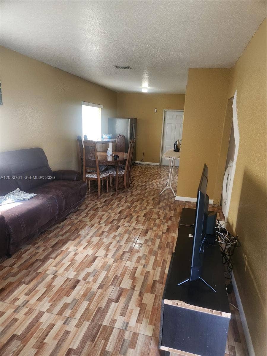 Multipurpose interior space featuring patterned tile flooring and a single-panel interior door