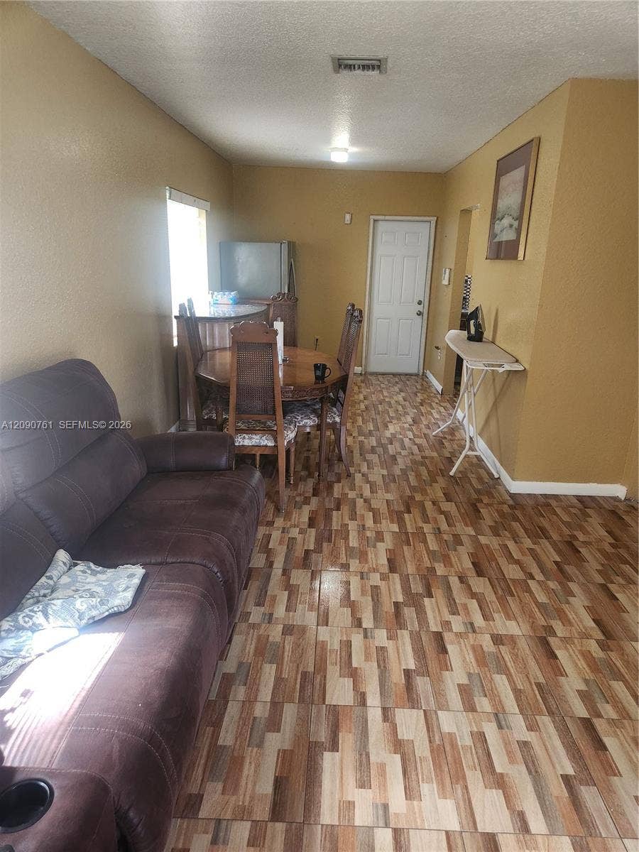 Multi-tonal patterned tile flooring, textured wall finishes, and a single-panel interior door