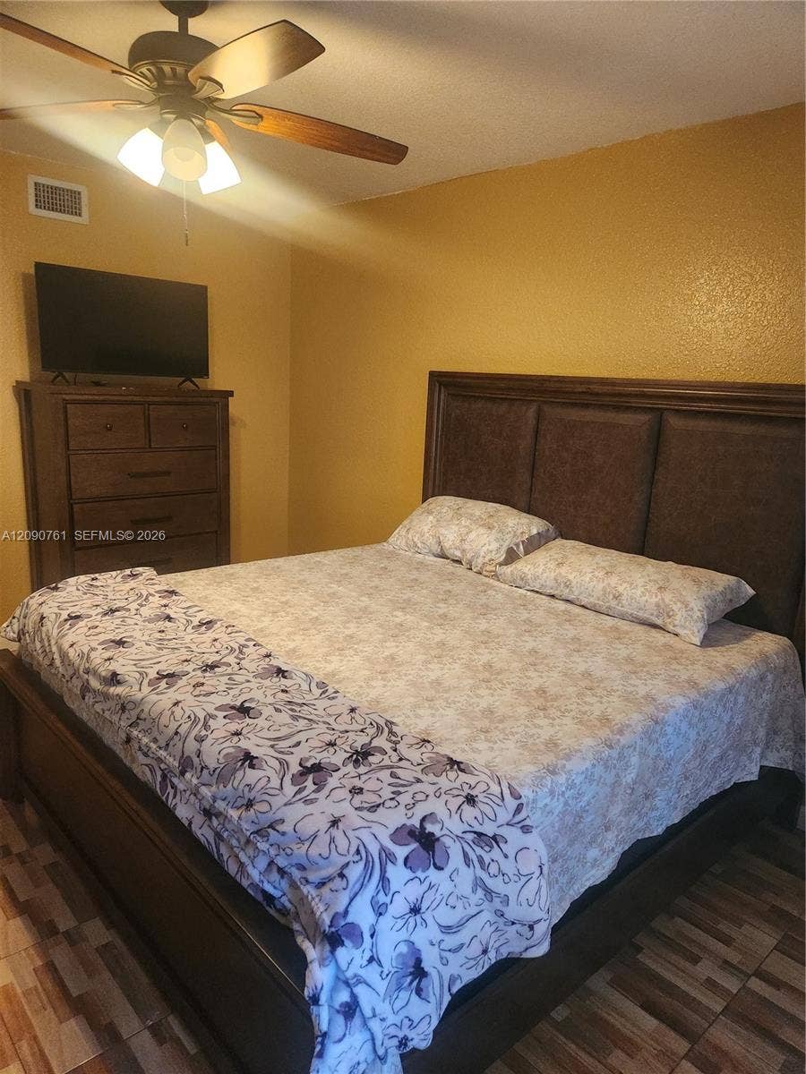 Multi-tonal tile flooring and ceiling-mounted fan with integrated light fixture
