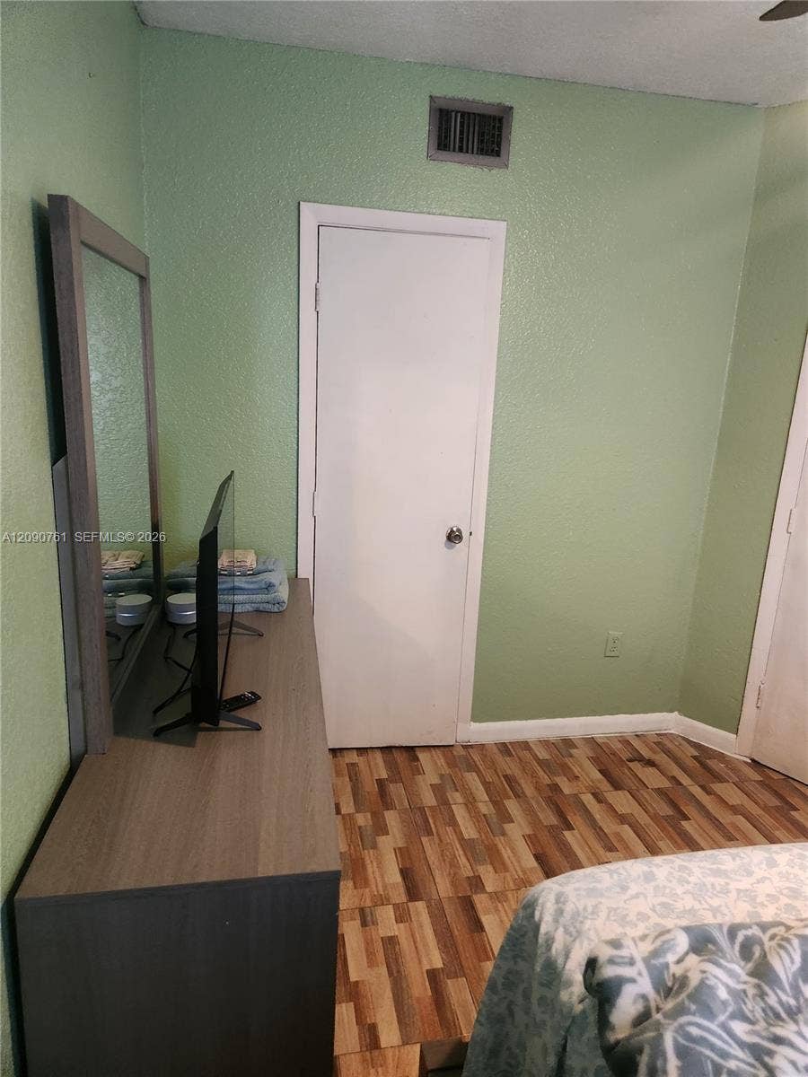 Interior space featuring wood-finish plank flooring and solid-core interior doors with metallic hardware