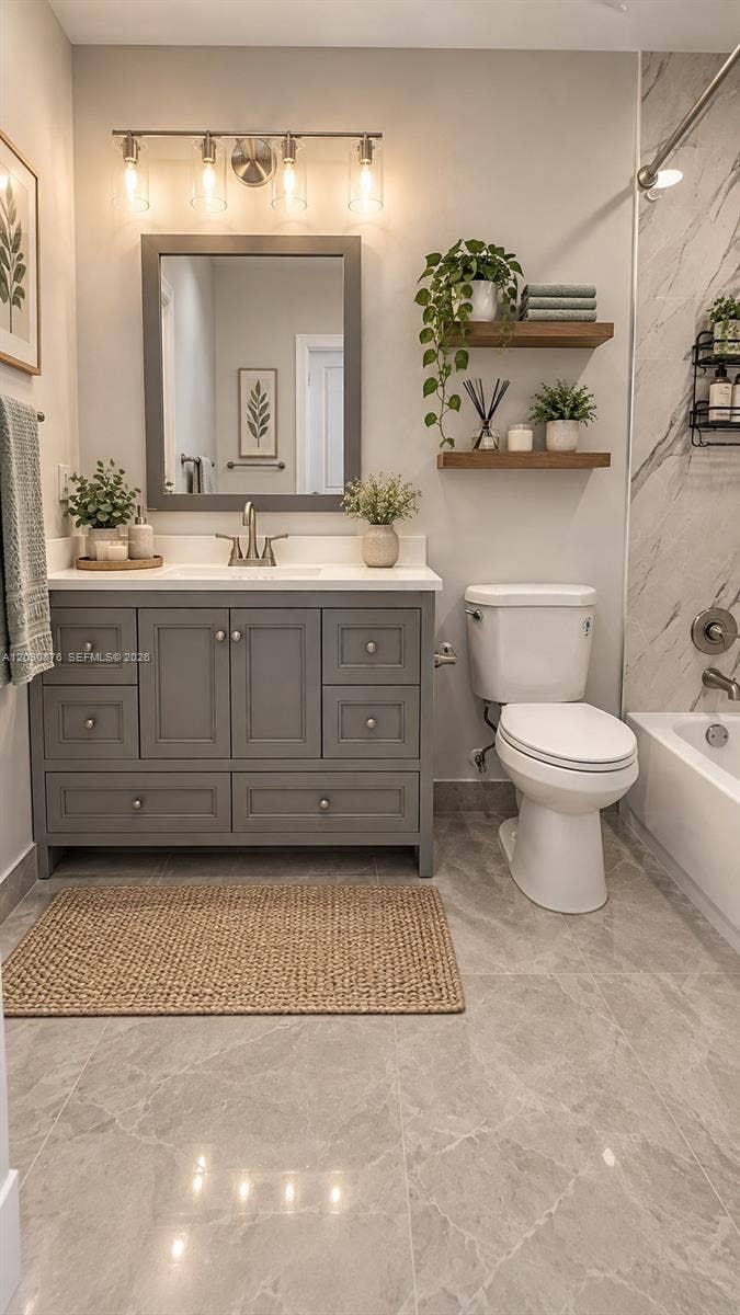 2196 Ensenada Terrace, Weston, FL 33327 Gray vanity with cabinet and drawer storage, white countertop with an undermount sink, brushed nickel faucet, and a framed mirror