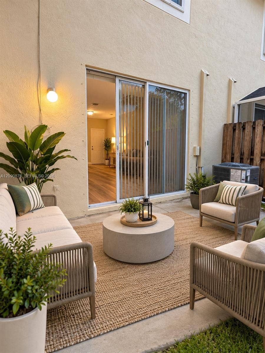 2196 Ensenada Terrace, Weston, FL 33327 Patio area with concrete surfacing, sliding glass door entry, and vertical blinds