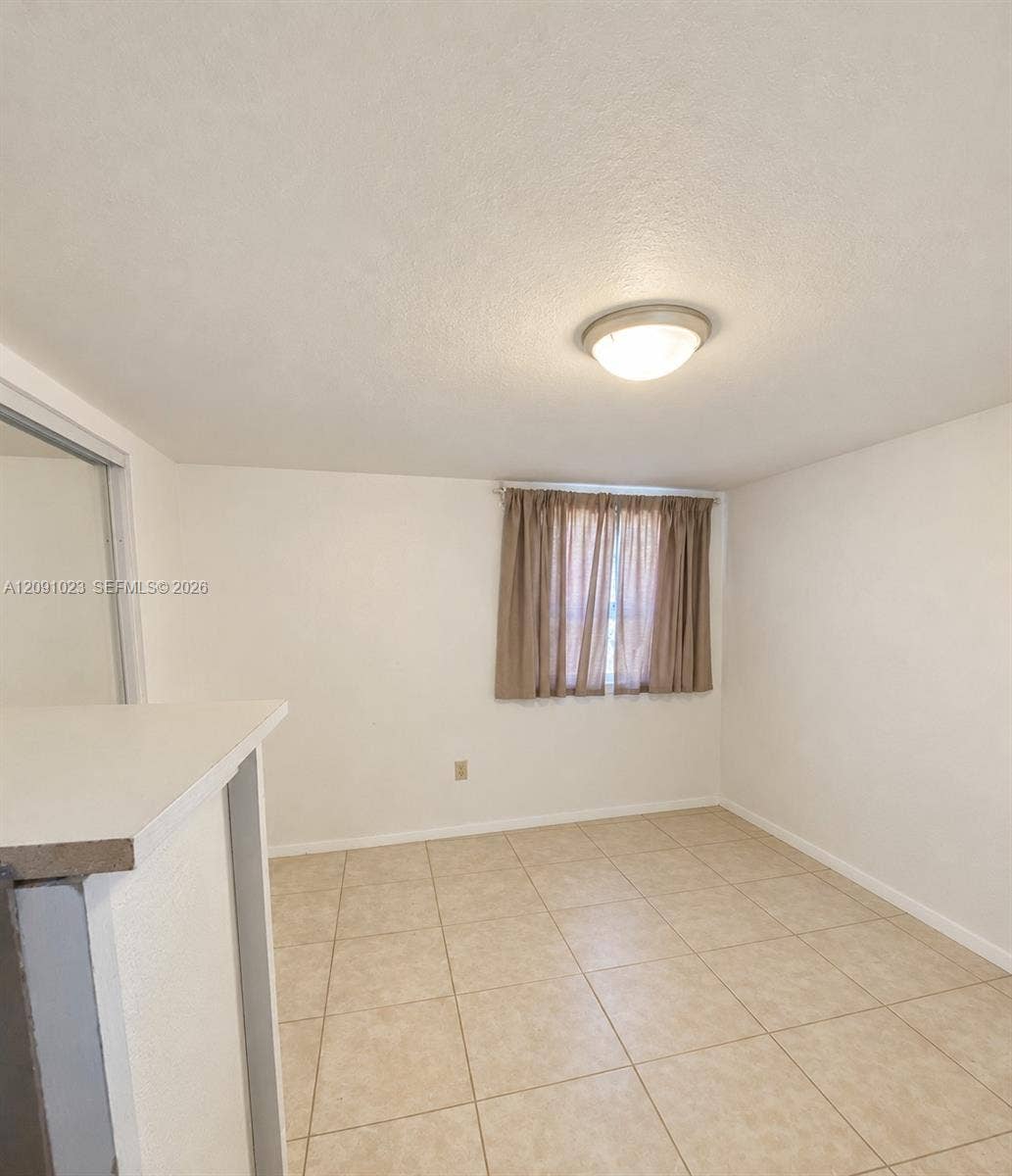Interior space featuring tile flooring, neutral walls, and a ceiling-mounted flush light fixture
