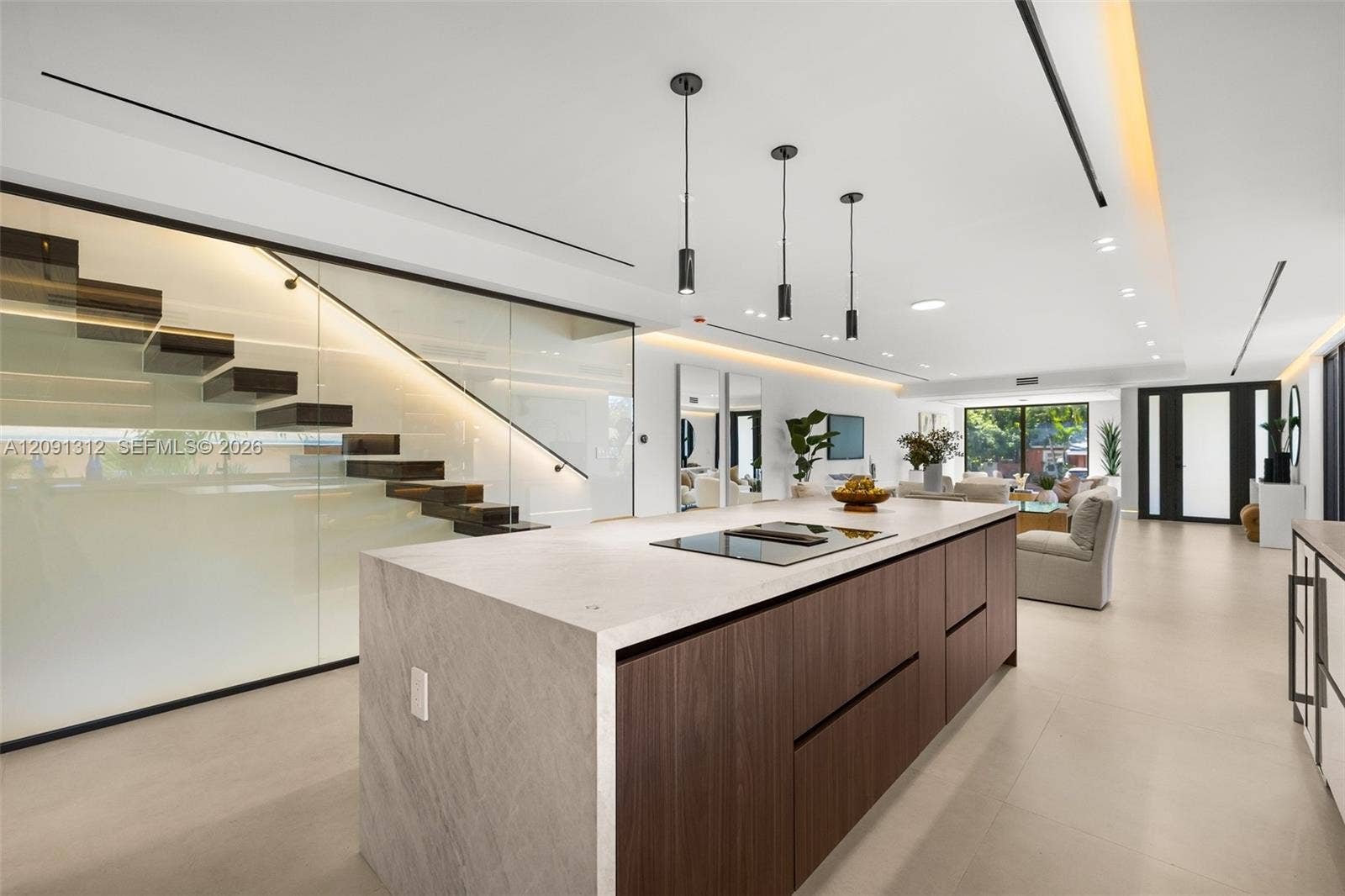 Center island featuring a stone-finish countertop, flat-panel wood cabinetry, and an integrated cooktop