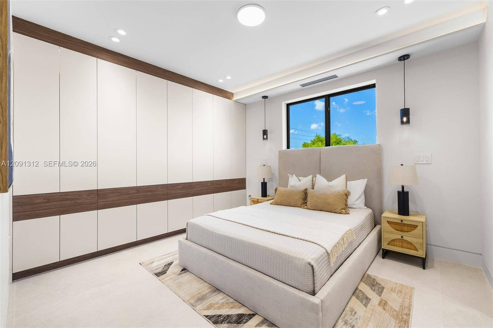Floor-to-ceiling built-in cabinetry with integrated wood-finish detailing, recessed lighting, and wall-mounted pendant fixtures