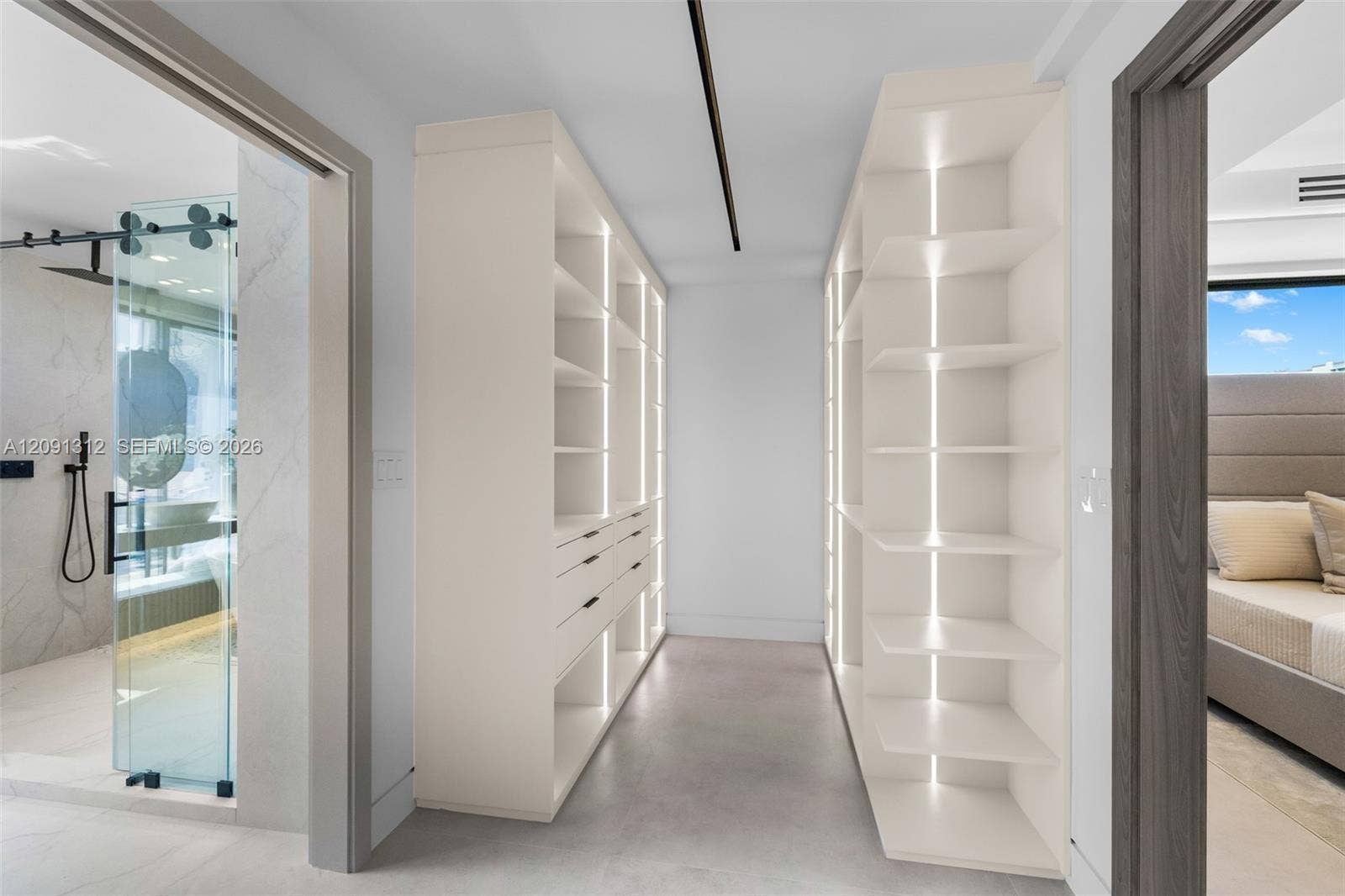 Custom walk-in closet featuring floor-to-ceiling built-in cabinetry, integrated vertical accent lighting, and multi-drawer storage units