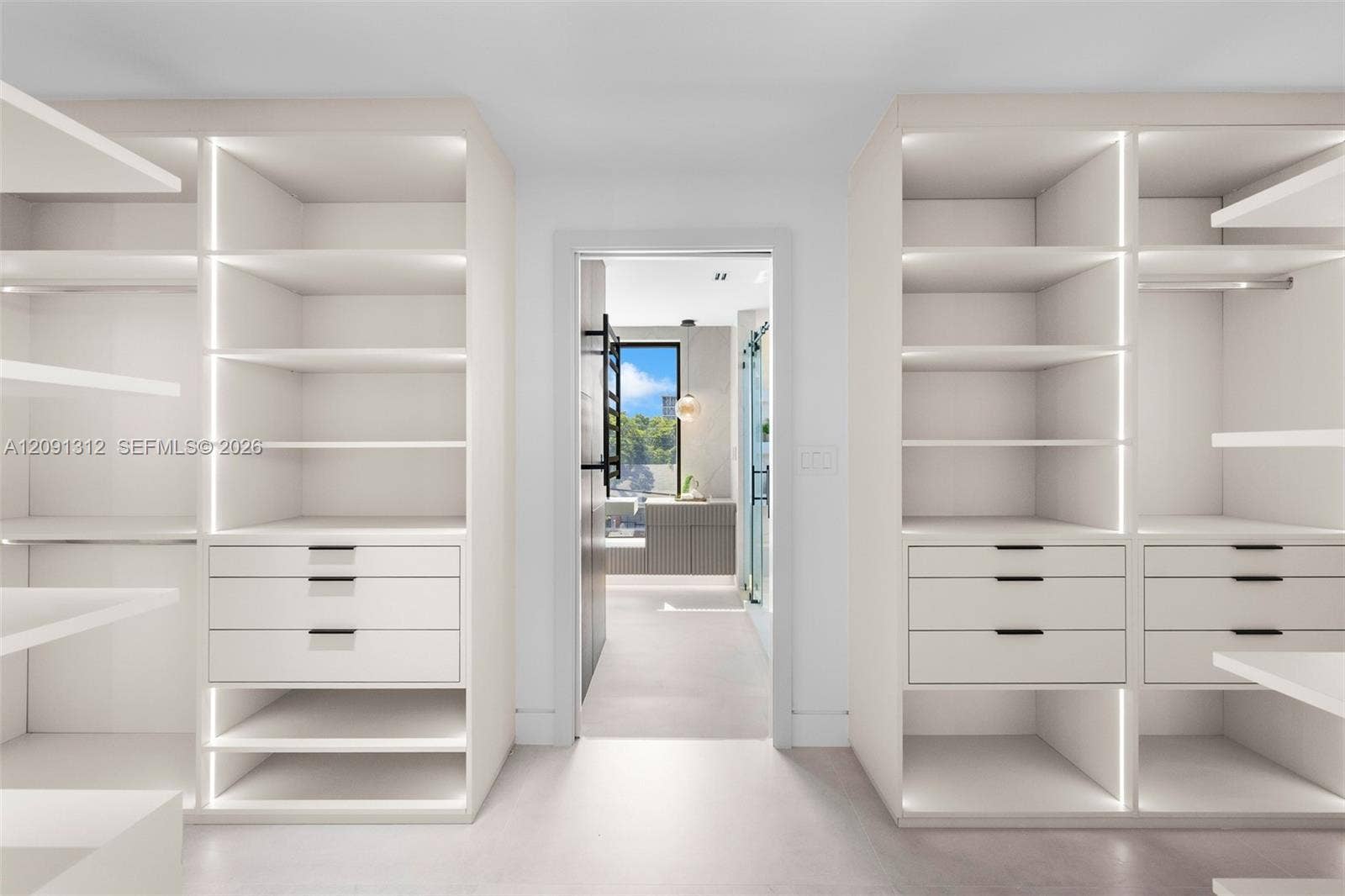 Custom floor-to-ceiling built-in cabinetry featuring integrated vertical LED lighting, matte black hardware, and soft-close drawers
