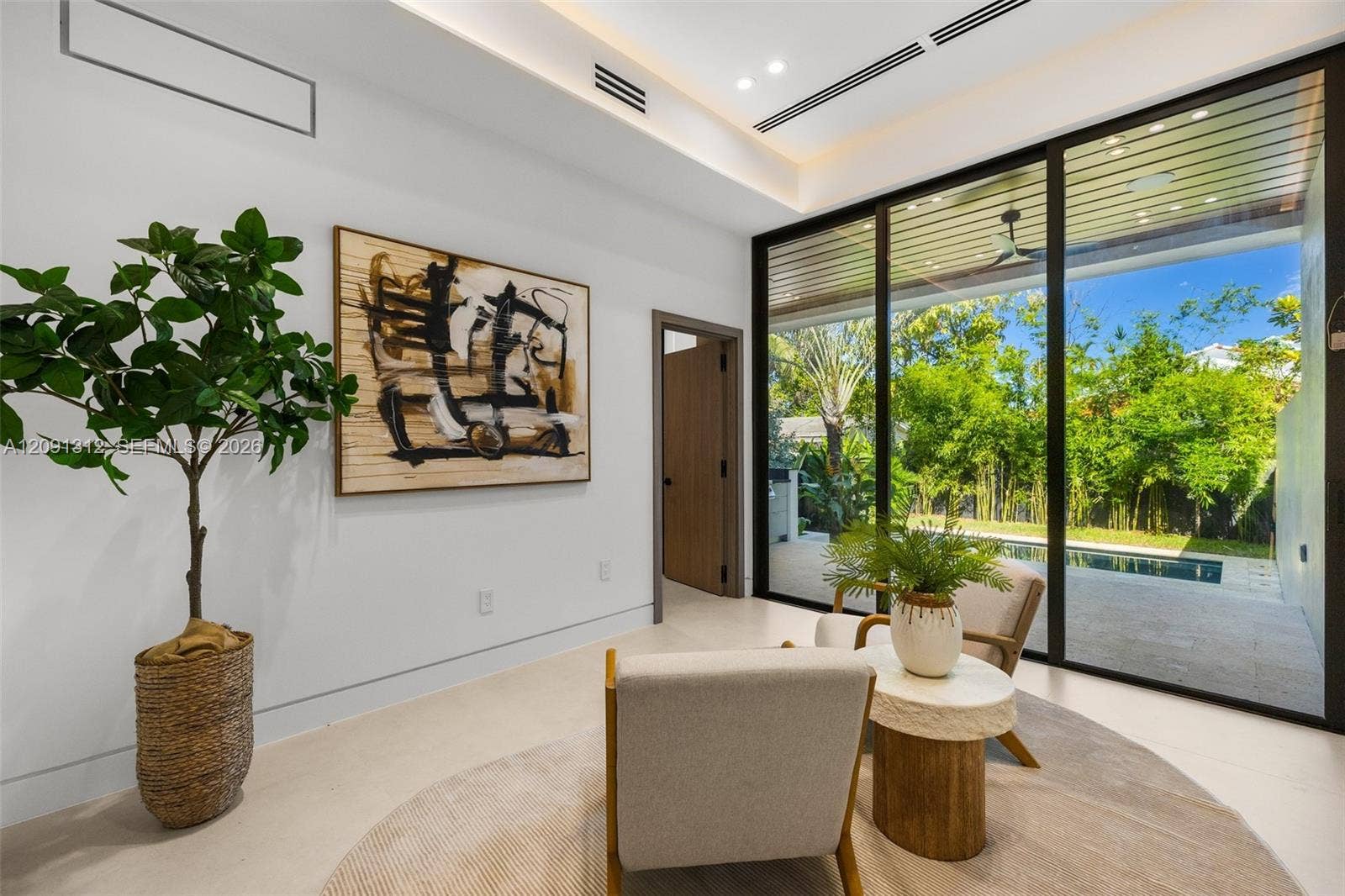 Floor-to-ceiling sliding glass walls, recessed cove lighting, linear ceiling vents, and smooth-finish flooring