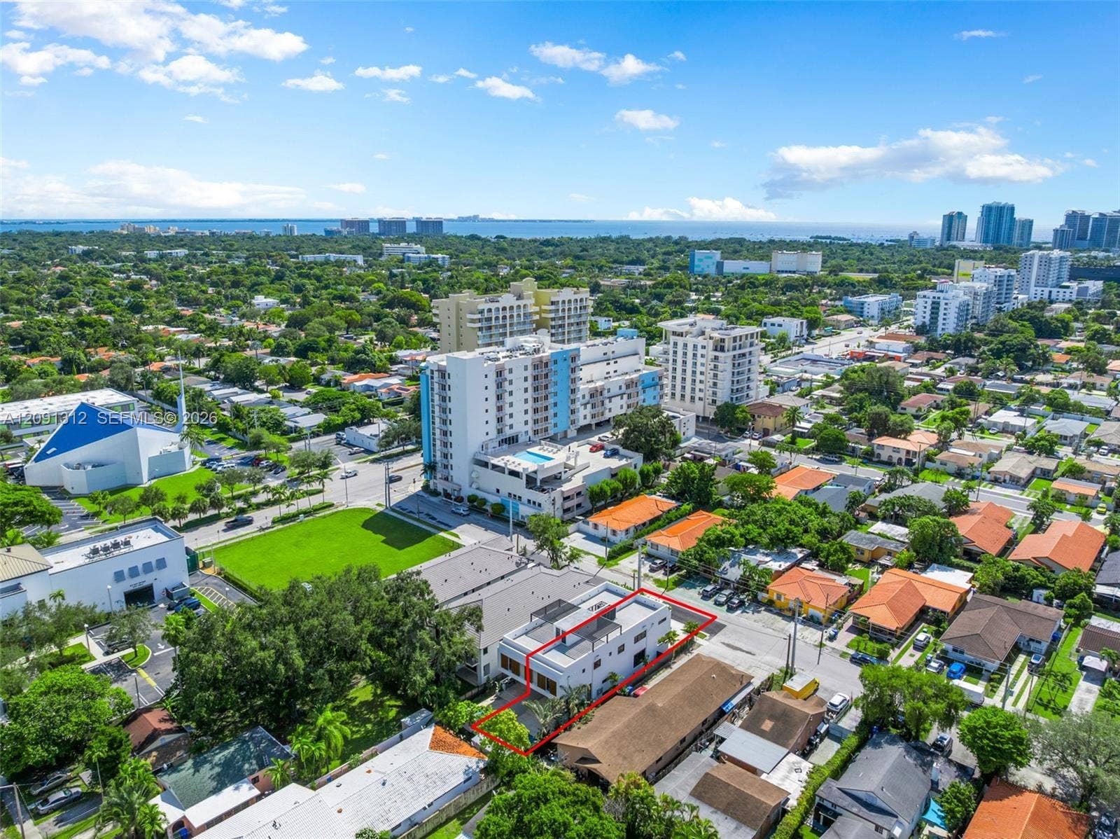 Aerial view of urban property featuring a flat-roofed building with a multi-level terrace