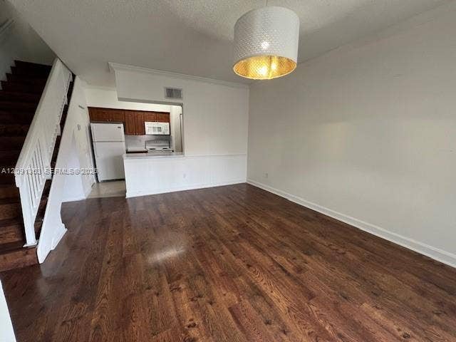 18356 NW 68th Avenue, #E, Hialeah, Hialeah, FL 33015 Wood-finish flooring, staircase with white railing, kitchen with dark wood cabinetry, white kitchen appliances, and textured drum pendant light fixture