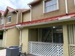 18356 NW 68th Avenue, #E, Hialeah, Hialeah, FL 33015 Stucco exterior featuring a red metal roof, decorative latticework railing, and double-hung windows