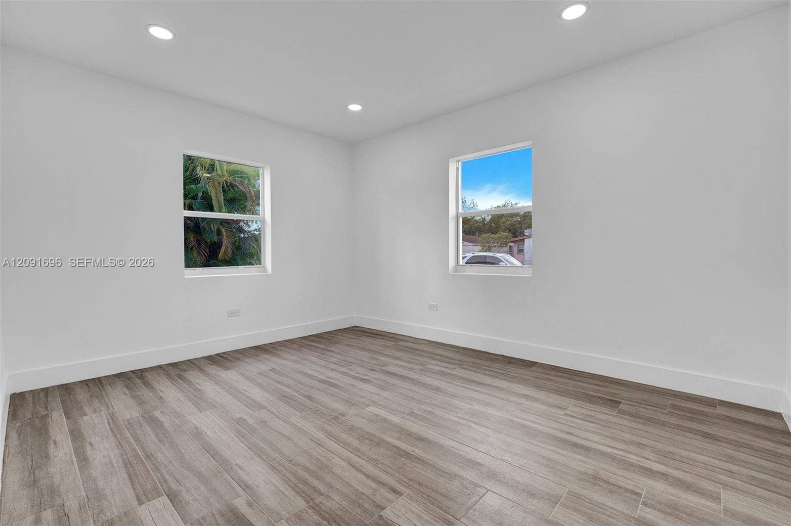 Neutral interior featuring wood-finish flooring, recessed lighting, and dual windows