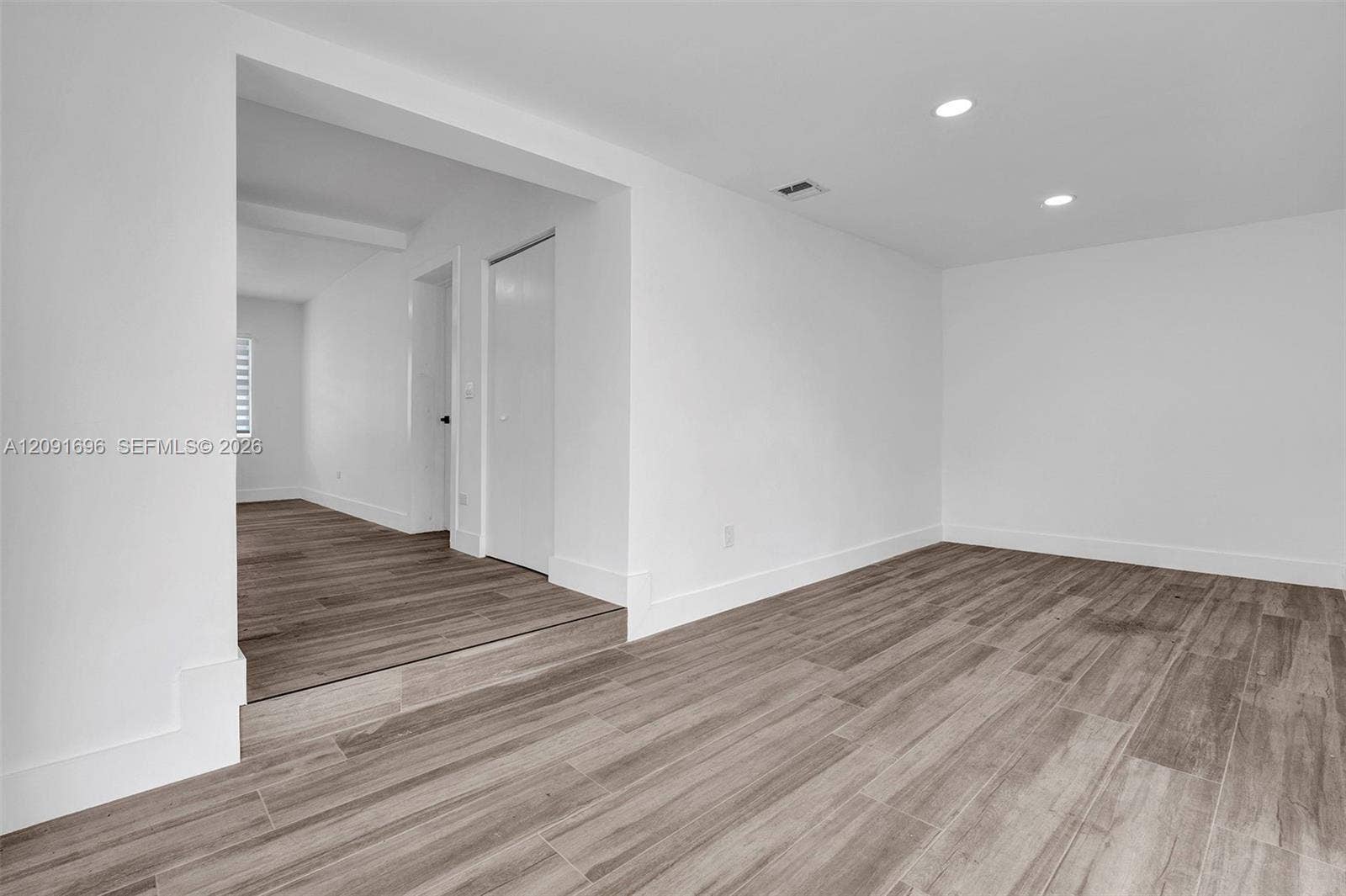 Interior space featuring wood-finish flooring, recessed lighting, and a white interior door