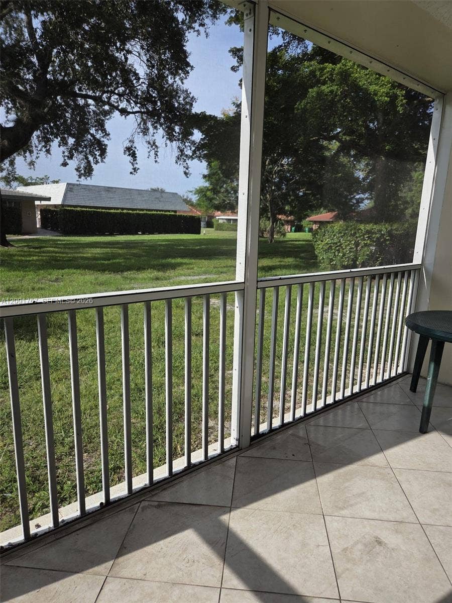 9101 W Sample Road, #102, Coral Springs, FL 33065 Screened-in porch featuring tile flooring and metal railing