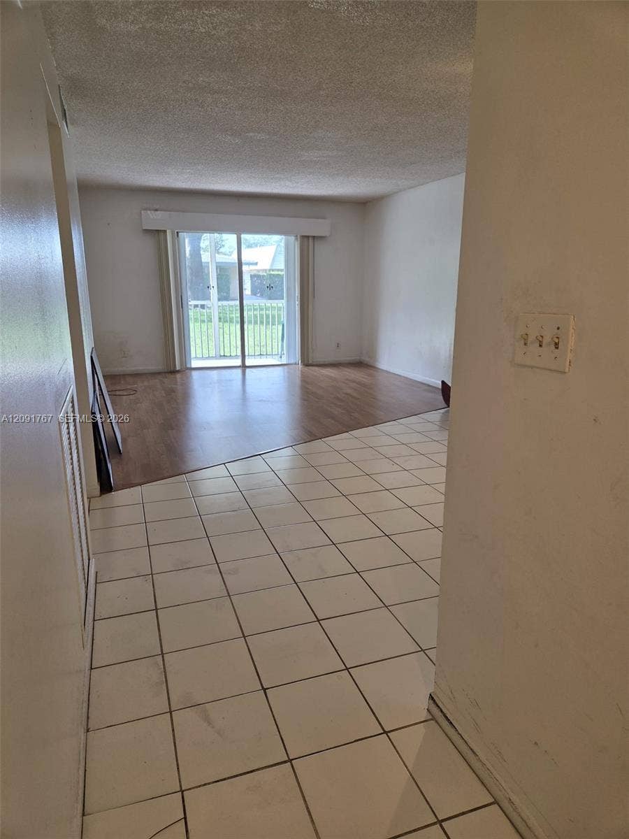 9101 W Sample Road, #102, Coral Springs, FL 33065 Interior space featuring ceramic tile flooring, wood-finish flooring, and sliding glass doors