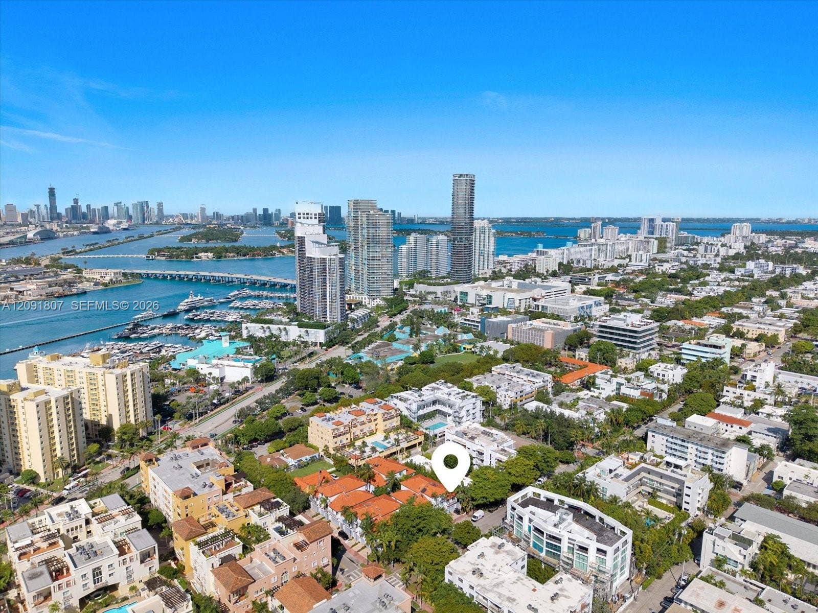 Aerial perspective of urban locale featuring proximity to waterfront, metropolitan skyline, marina, and major bridge infrastructure